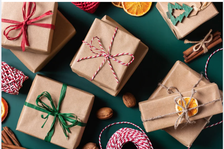 Image of presents wrapped in brown paper with red and green ribbon and a dark green background for Favorite Things Party blog post.