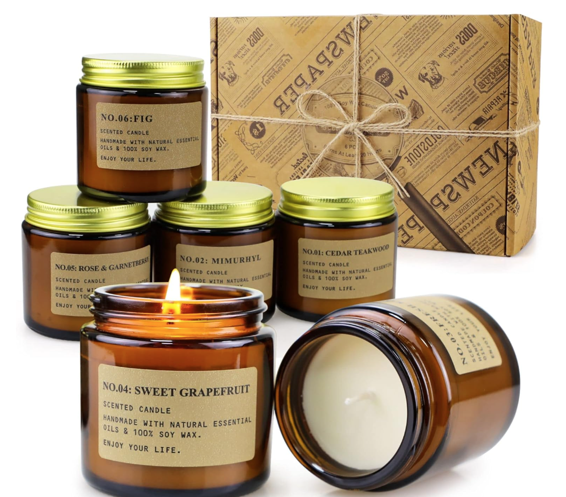 household essentials shopping list. Image of 6 candles of different scents in amber jars with cardboard box in background.