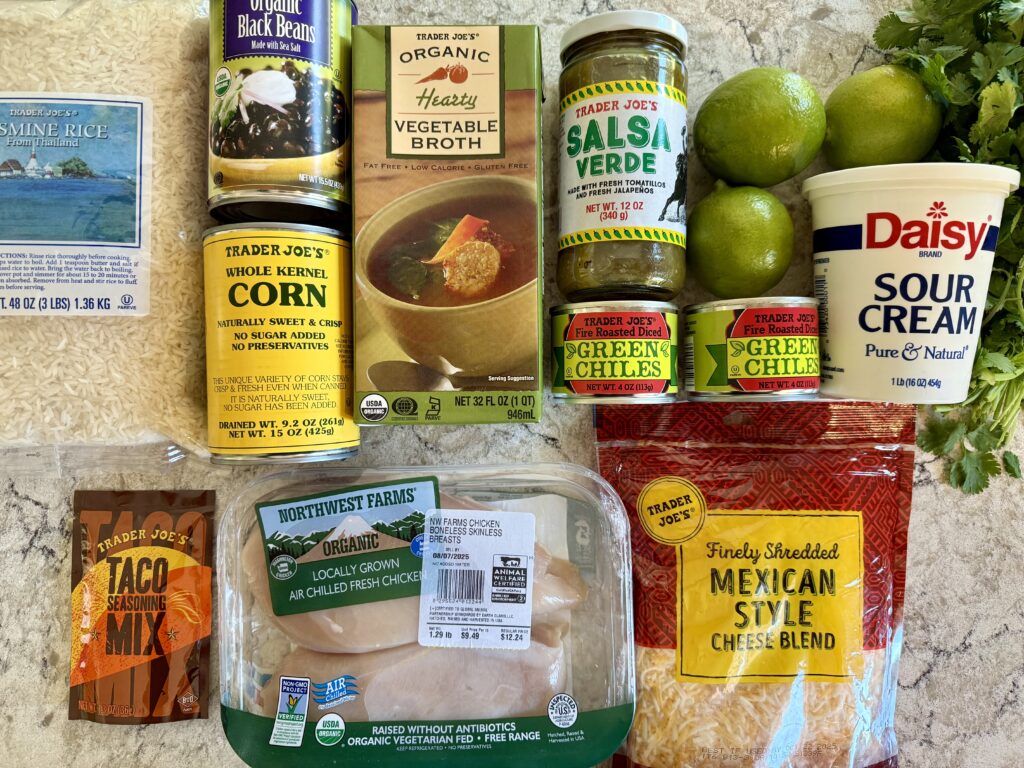 best southwest chicken casserole recipe. Image of ingredients for recipe: rice, black beans, corn, vegetable broth, salsa verde, green chiles, limes, cilantro, sour cream, taco mix, chicken, and cheese.