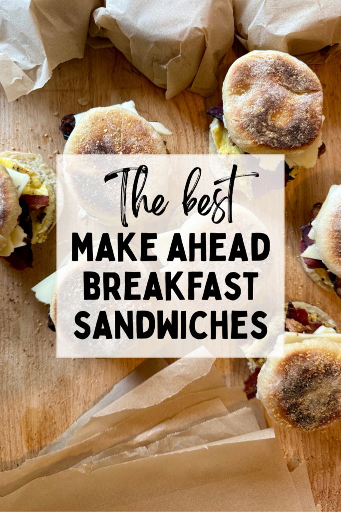 Image that says "the best make ahead breakfast sandwiches". Picture of English muffin breakfast sandwiches on wood cutting board.