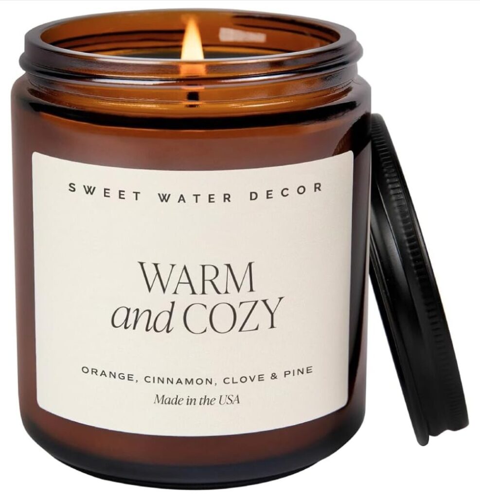 Gift ideas for host. Image of candle in amber glass jar with label that says "warm and cozy". 