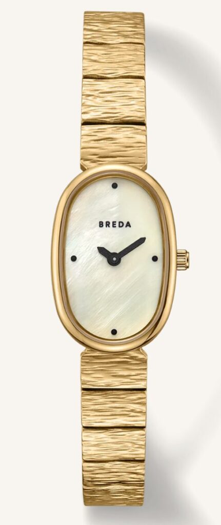 Christmas gift ideas for her jewelry. Image of gold watch with oval watch face with pearl color background.