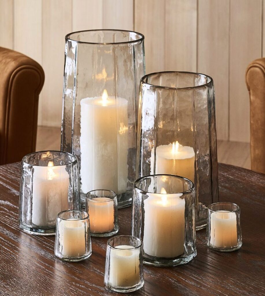 gifts when she has everything. Image of white candles in glass candle holders on wooden table.