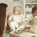 family traditions list. Image of mom and two daughters baking in kitchen. All three are dressed in white.