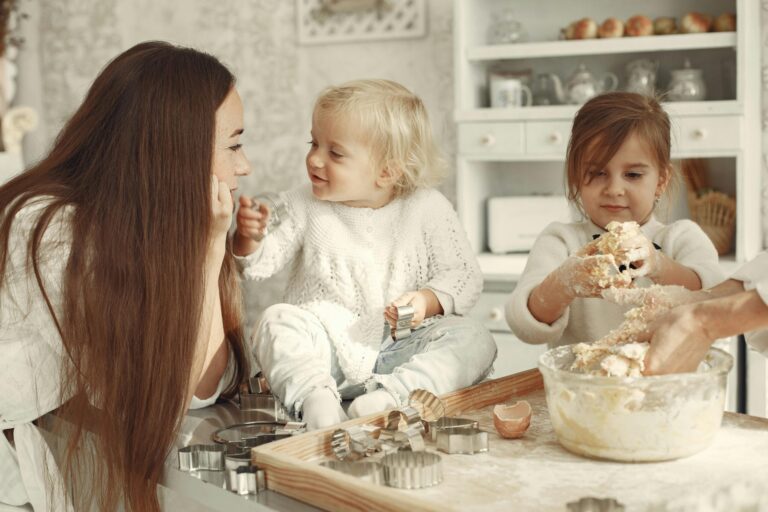 family traditions list. Image of mom and two daughters baking in kitchen. All three are dressed in white.