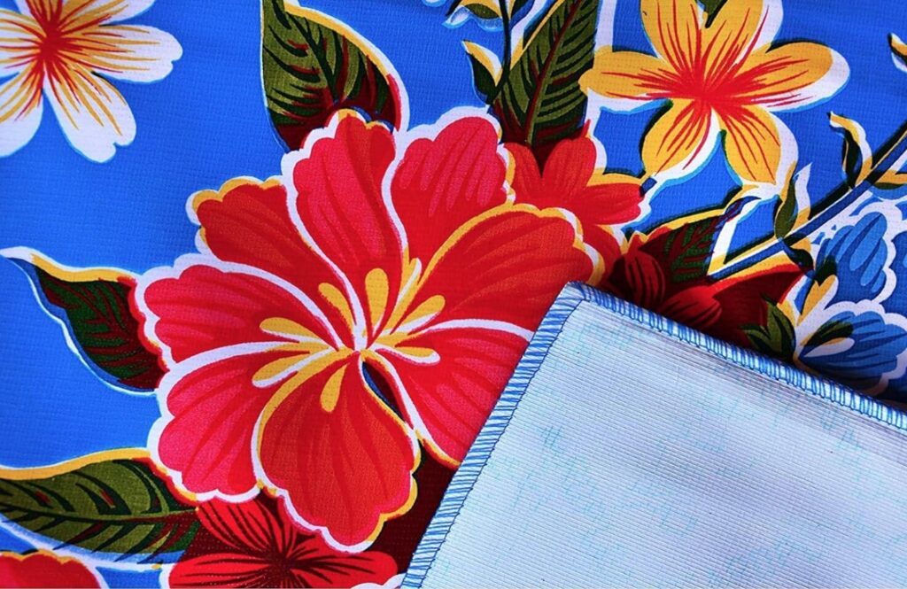 image of blue tablecloth with red, yellow, and white flowers.