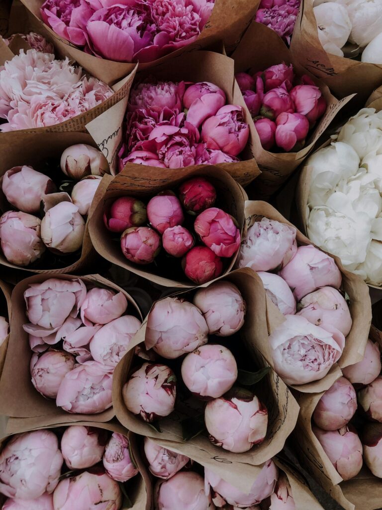 valentines day gift ideas image of pink and white bouquets of flowers wrapped in brown paper.