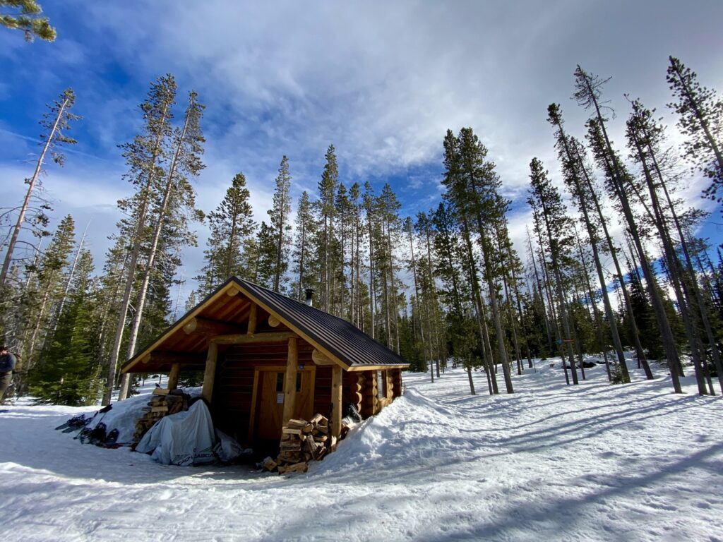winter family traditions ideas. Image of log cabin in snowy mountains.