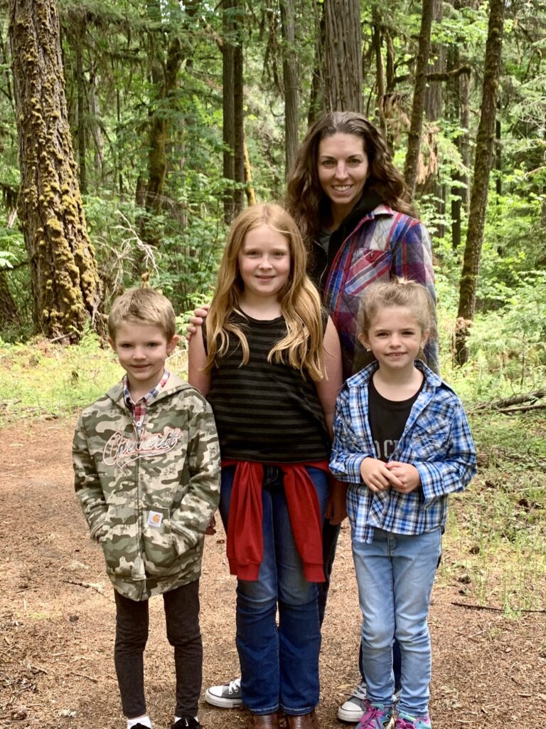 honest motherhood. Image of mom and three kids (two girls and boy) hiking in forest.
