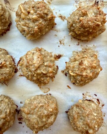 chicken parmesan meatballs recipe, closeup image of chicken parmesan meatballs on parchment paper.