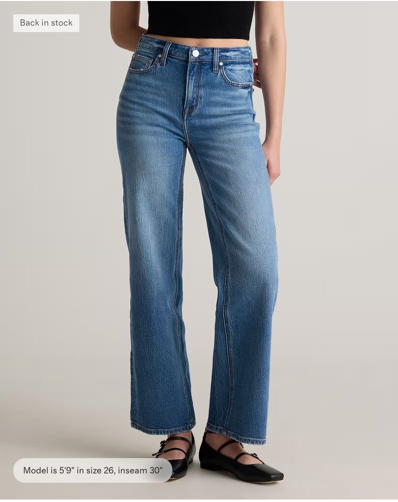 image of woman wearing denim jeans with black top. 