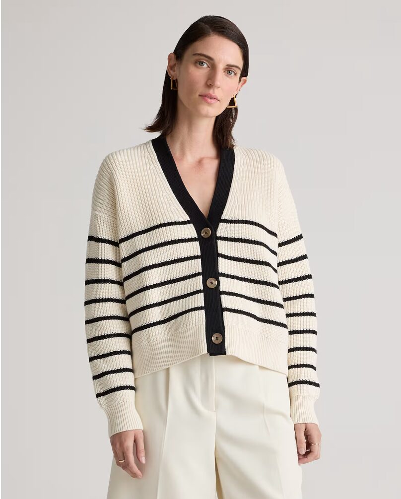 woman wearing ivory cardigan with black stripes. 